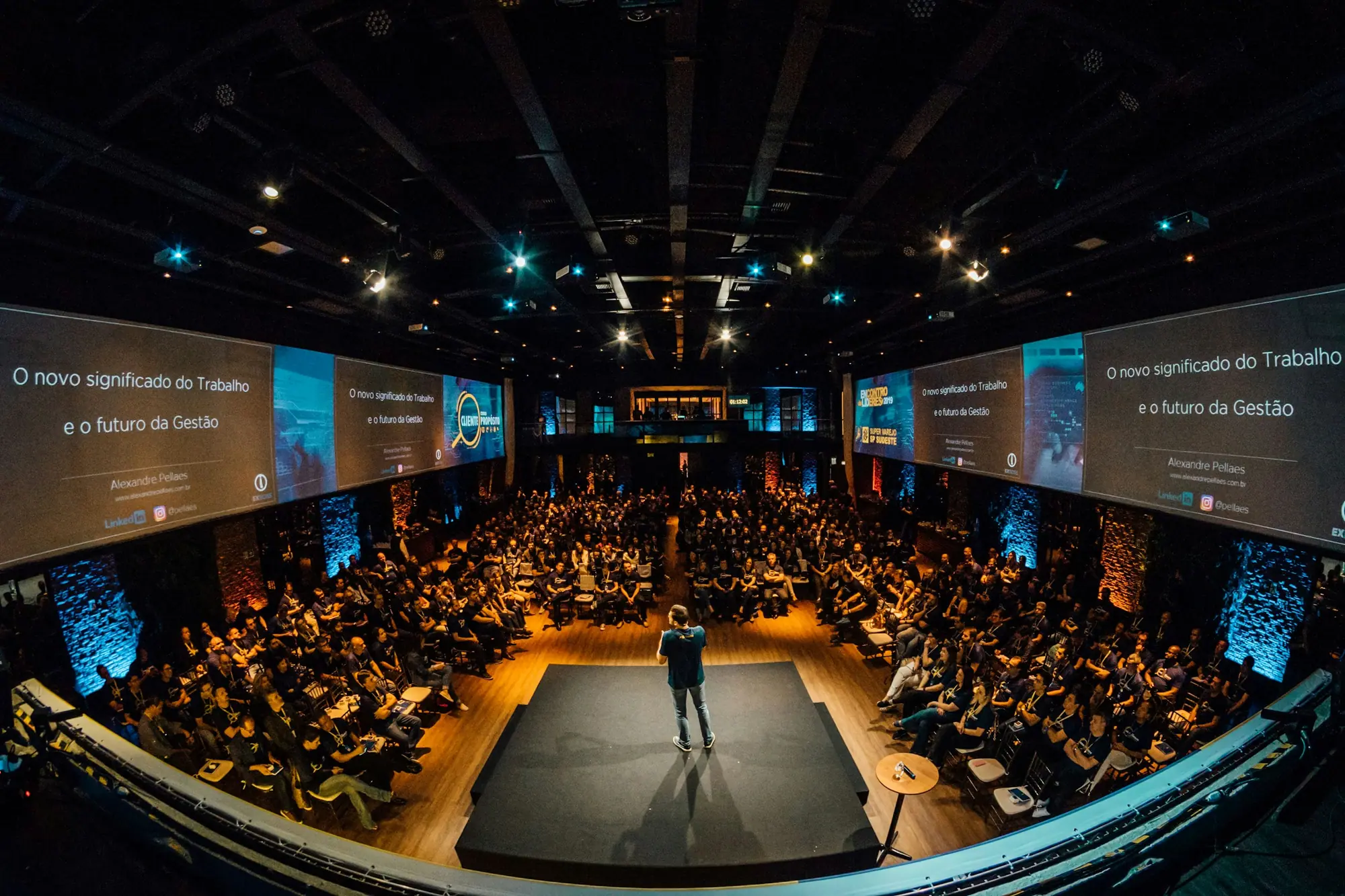 Speaker on stage addressing a packed conference auditorium