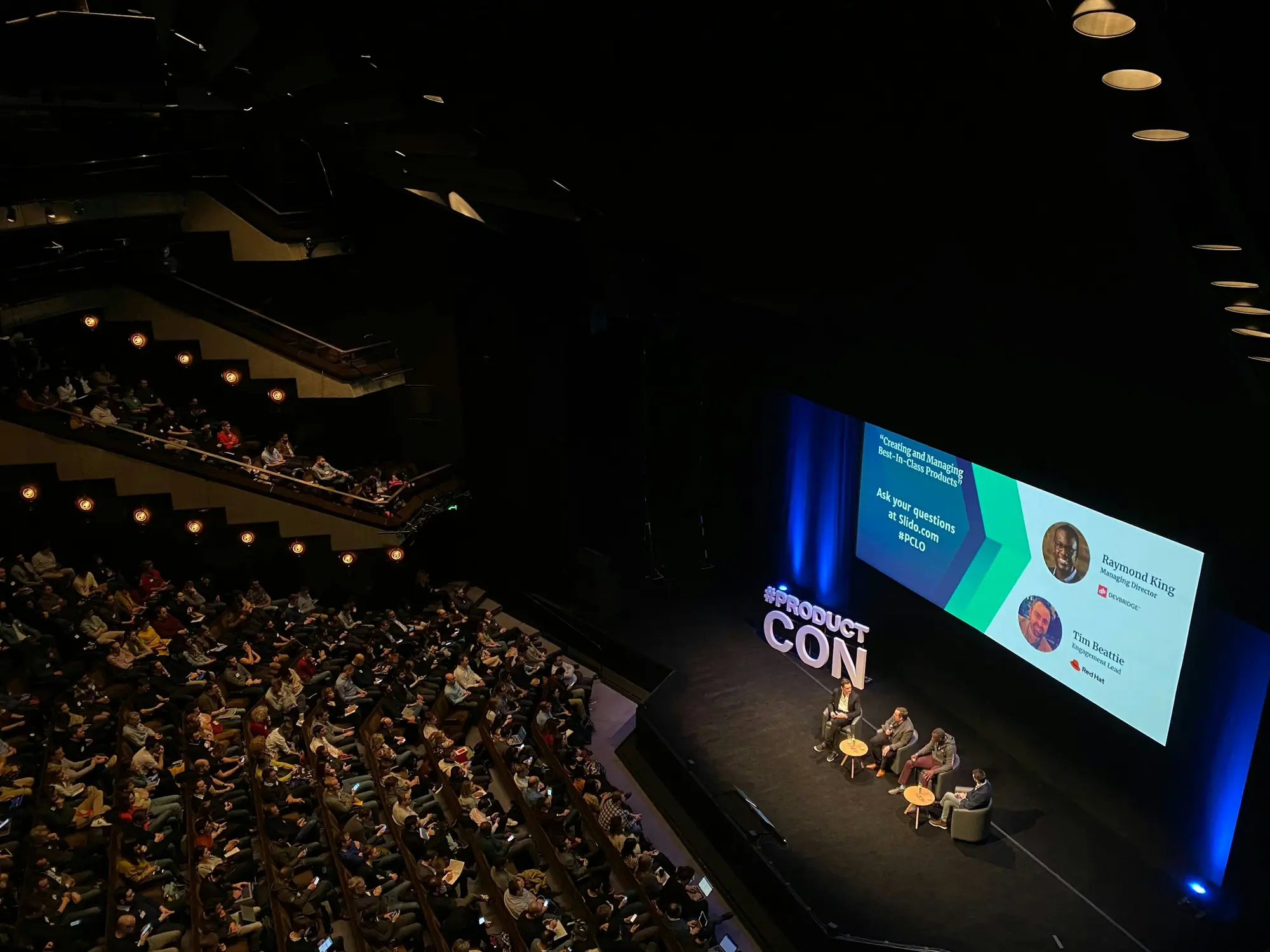 Panel discussion on a lit stage in front of a large audience